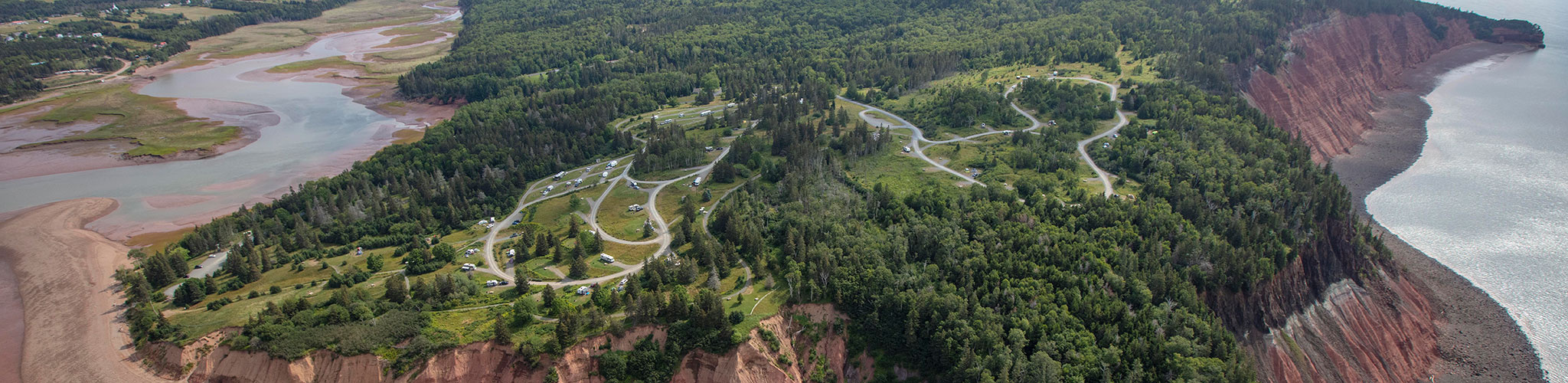 Aerial view of Five Island Park showcasing the cliffs of red mud, forest and ocean