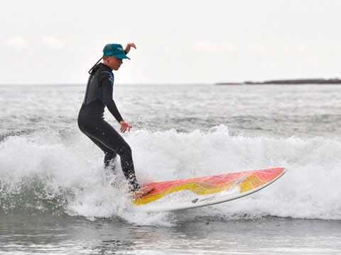 young man surfing on a wave making its way to shore