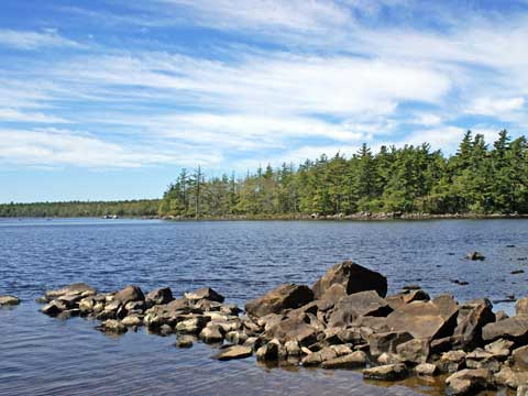 Overlooking rocky formation reaching out into Ten Mile Lake from beach side 